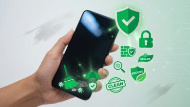 يد تمسك هاتفاً نظيفاً ولامعاً مع أيقونات حماية خضراء حوله — يرمز لتنظيف الجهاز وتحصينه.
